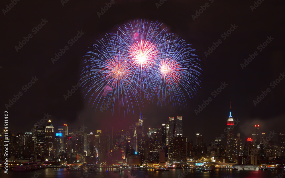 Fireworks lighting up the city and reflecting over the river during a festive night celebration Fireworks lighting up the city and reflecting over the river during a festive night celebration
