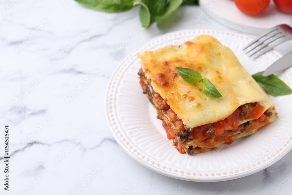 Delicious cooked lasagna with basil served on white marble table, closeup. Space for text Delicious cooked lasagna with basil served on white marble table, closeup. Space for text