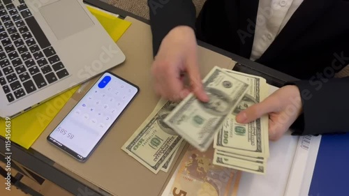 Two hands holding cash as part of a transaction in an office setting with documents on the table. High quality HD footage