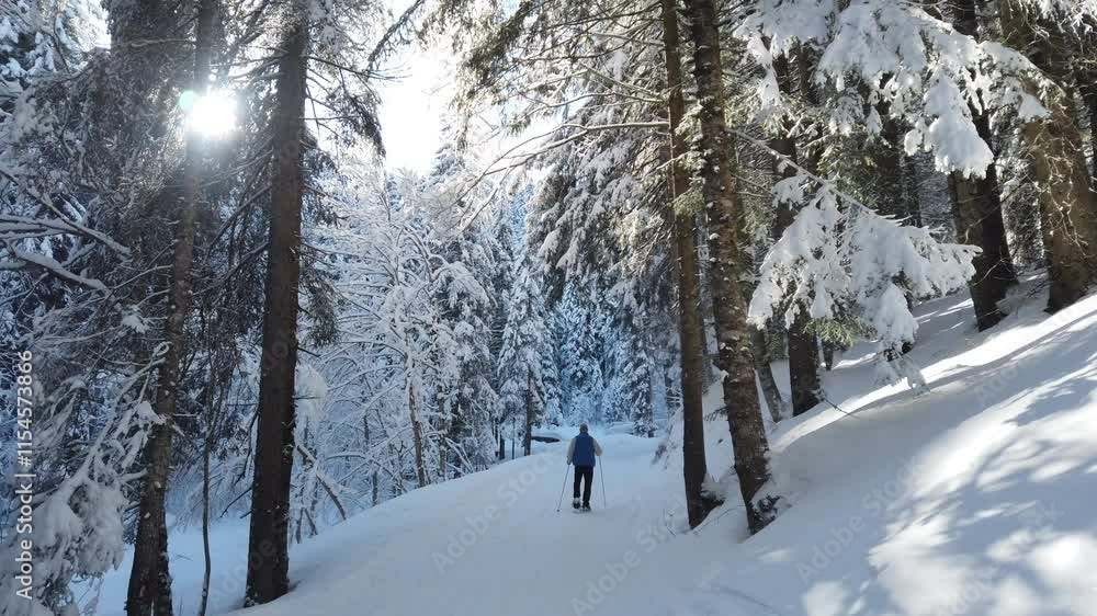 Man is walking on the path fully covered with snow and tranquil mountain scene Man is walking on the path fully covered with snow and tranquil mountain scene