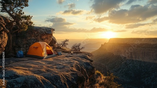 A rugged camping setup on a rocky cliff edge, overlooking a vast valley during sunset.