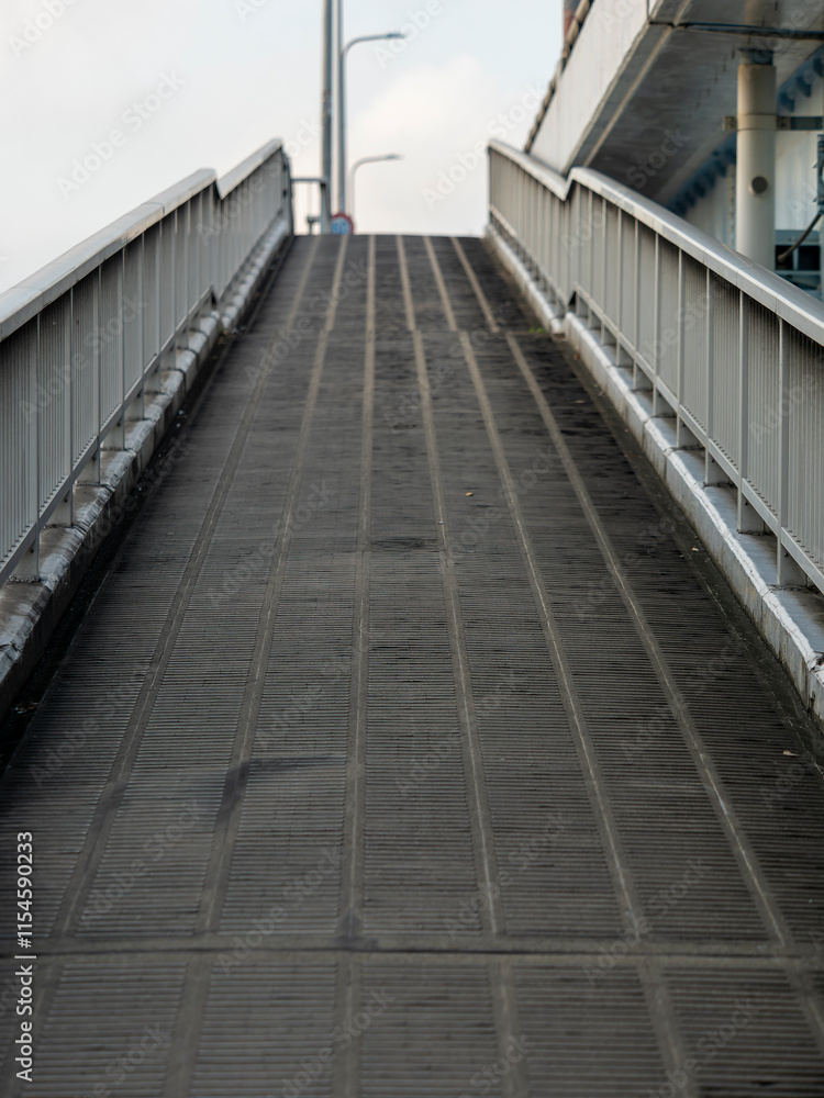 Obraz premium 川を渡る歩道橋の坂道