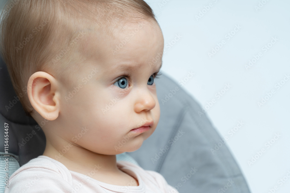 Thoughtful baby with bright blue eyes and a side profile Thoughtful baby with bright blue eyes and a side profile