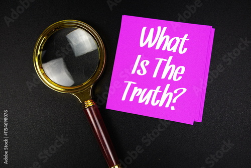 What Is The Truth? text on sticky note with magnifying glass on black background photo