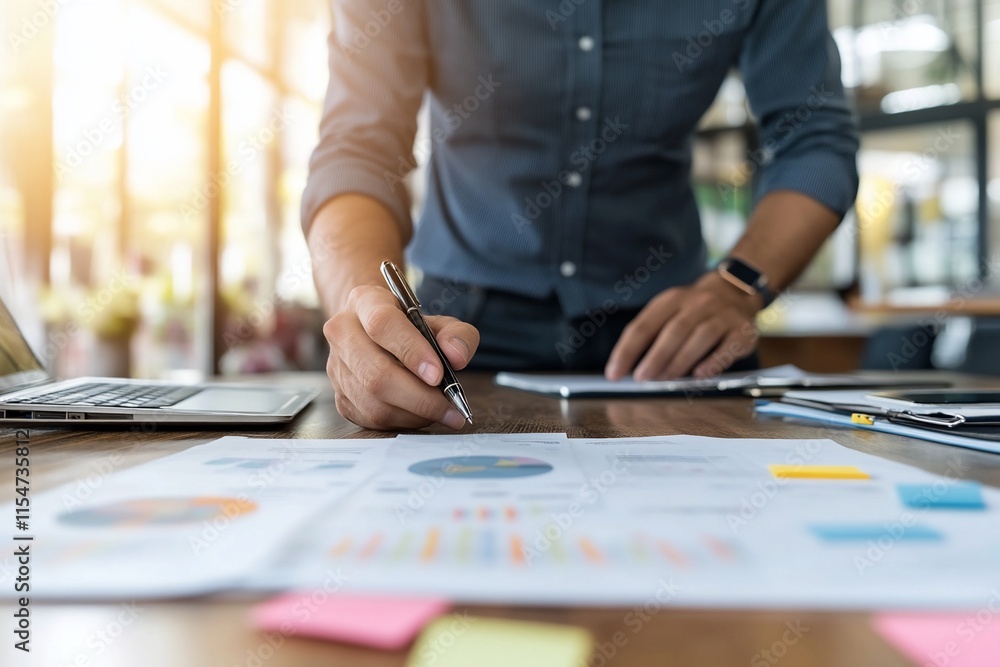 Businessman reviewing financial charts and graphs at his desk. Businessman reviewing financial charts and graphs at his desk.