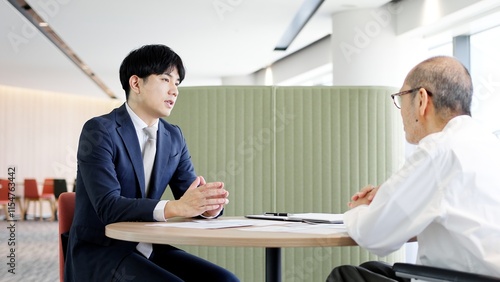 高齢者に営業をするビジネスマン	