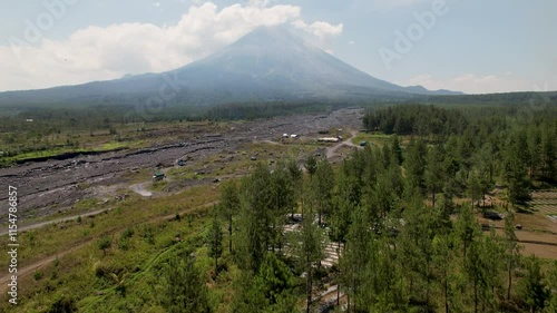 4K Drone Video flying up to view Semaru Volcano, surrounded by green forest landscapes and molton rock in East Java Indonesia photo