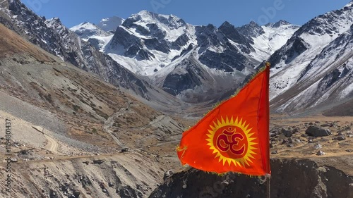 Om flag fluttering near Om Parvat is a sacred peak in the Himalayas whose snow deposition pattern resembles the sacred 'Om'. Situated in Uttarakhand, India photo