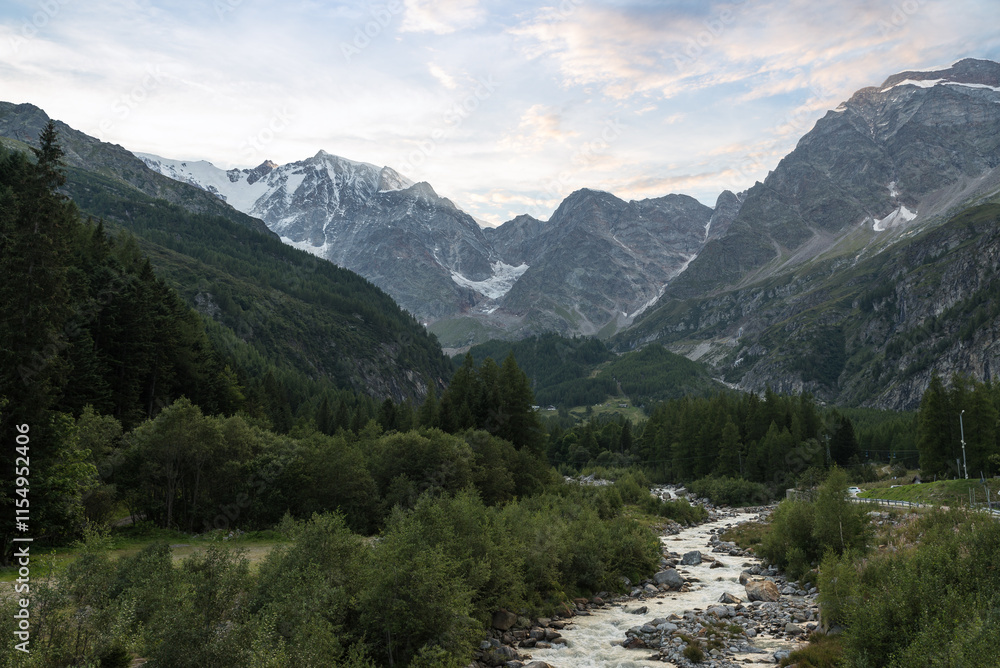 Fototapeta premium Alpine Valley with river, mountains and glaciers, in summer at sunset. Macugnaga in Anzasca Valley and Monte Rosa, Italy