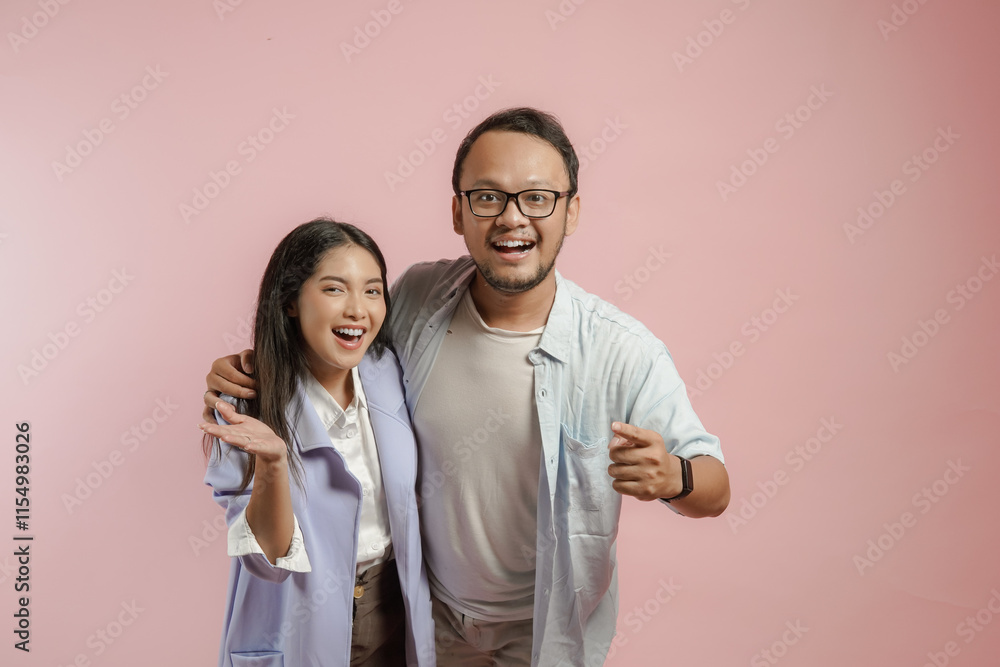Smiling young Asian couple hugging each other while doing a welcome gesture. Smiling young Asian couple hugging each other while doing a welcome gesture.