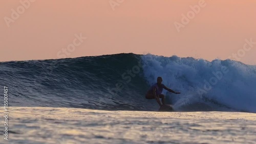 Female surfer on a wave at sunset time at Indian Ocean. High quality 4k footage