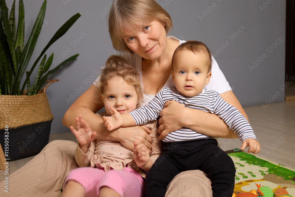 A grandmother enjoys a warm moment cuddling her two grandchildren in a comfortable living space filled with natural light and indoor plants A grandmother enjoys a warm moment cuddling her two grandchildren in a comfortable living space filled with natural light and indoor plants