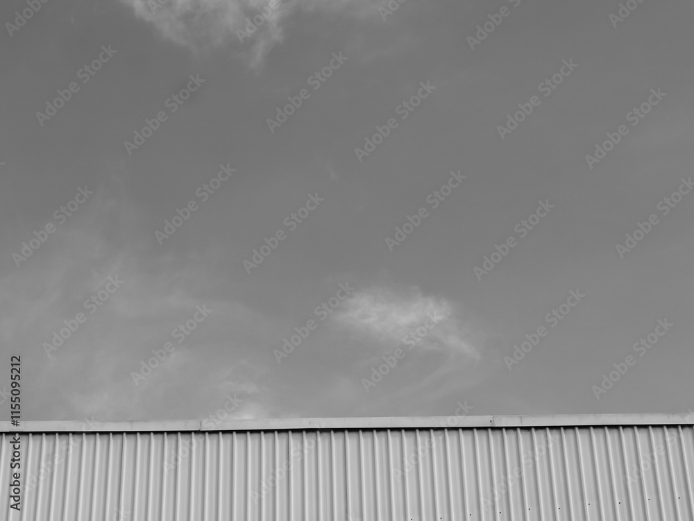 Black and white of industrial factory building with aluminum metal texture on the exterior wall, modern architecture of corrugated steel facade. Copyspace, design. Black and white of industrial factory building with aluminum metal texture on the exterior wall, modern architecture of corrugated steel facade. Copyspace, design.