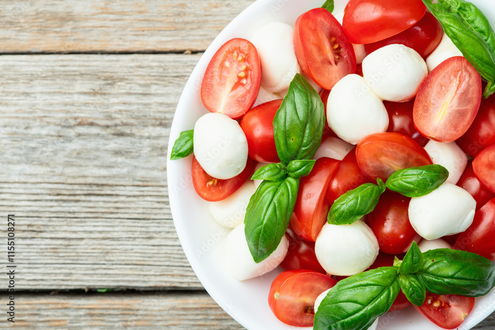 Basil leaves , cherry tomatoes and mozzarella cheese . In bowl food photography Basil leaves , cherry tomatoes and mozzarella cheese . In bowl food photography