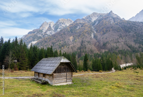 Drone aerial of wooden mountain hut overlooking valley julian alps, slovenia. photo