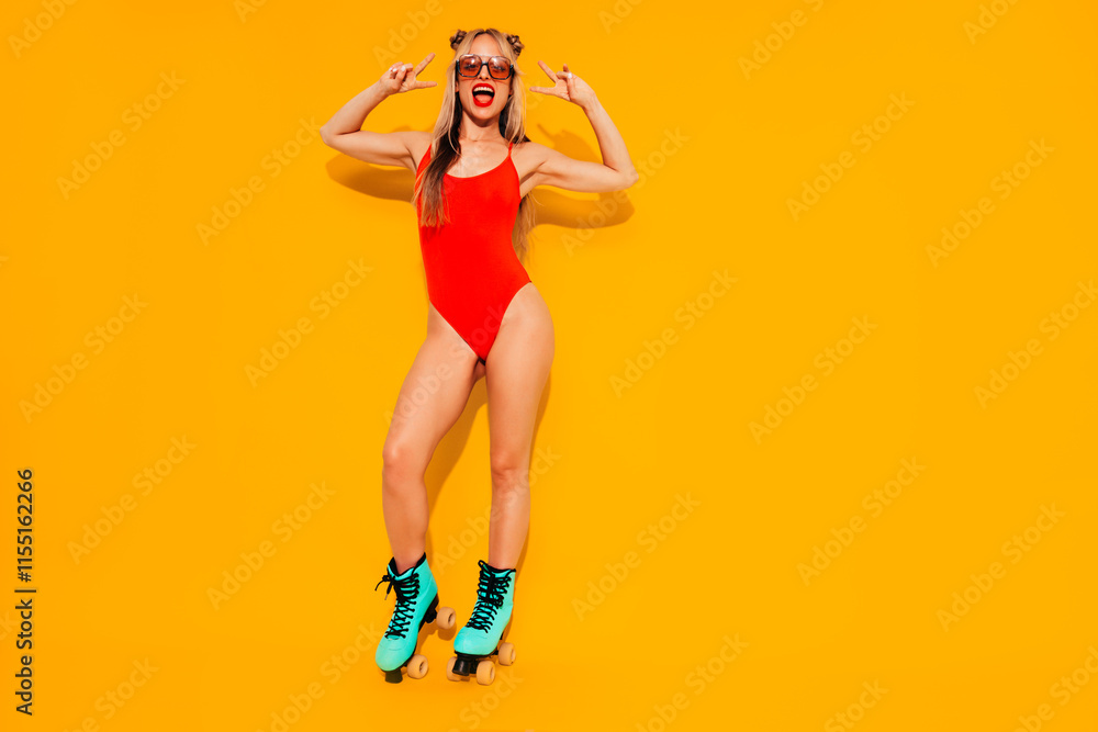 Young smiling blond model in red summer swimwear bathing suit. Sexy carefree woman having fun. Hot female isolated on yellow wall in studio. Cheerful and happy, riding quad rollers, full length Young smiling blond model in red summer swimwear bathing suit. Sexy carefree woman having fun. Hot female isolated on yellow wall in studio. Cheerful and happy, riding quad rollers, full length