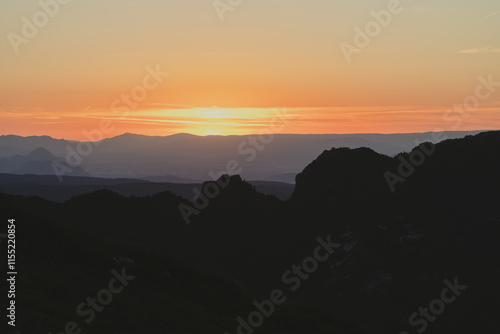 Atardecer entre las montañas con tonos naranjas