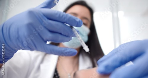 Amazing slow motion shot of a dermatologist doctor injecting Botox into a patient's forehead at a clinic during a beauty treatment.