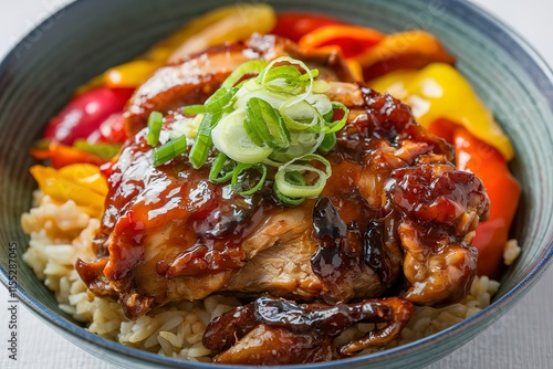 a bowl of sumptuously glazed chicken meat, garnished with thinly sliced green onions