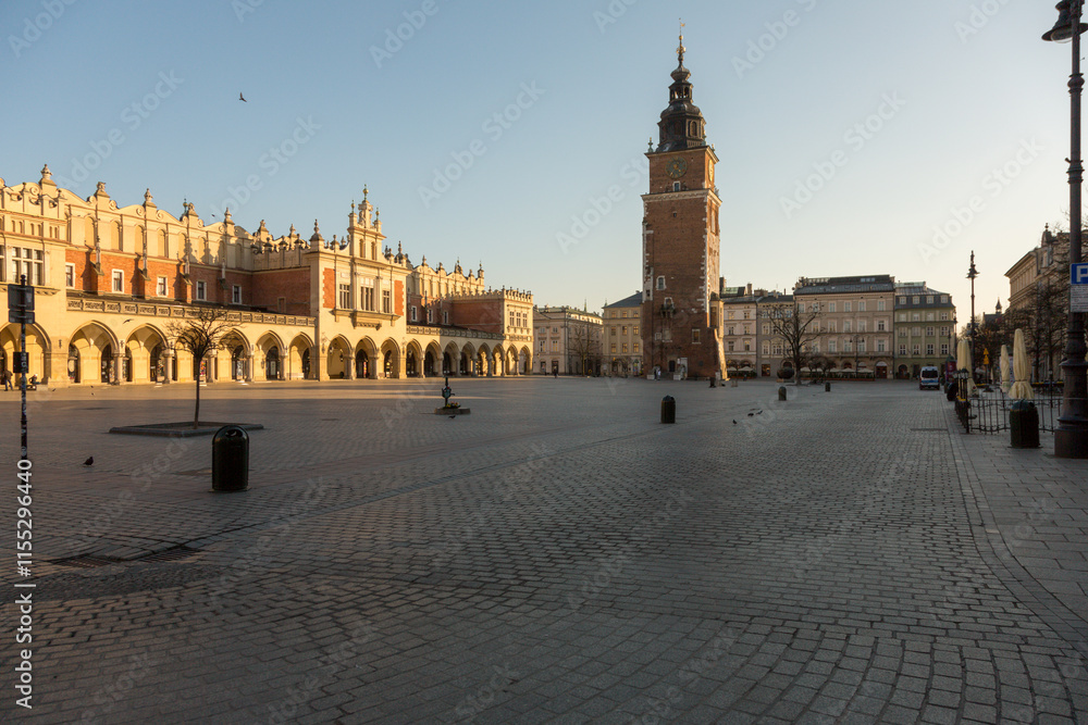 Naklejka premium Krakow, Poland - 04.09.2020: the market hall, tower and the empty Market Square during golden hour