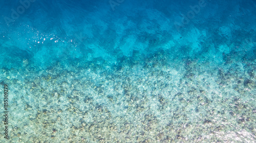 Obraz na płótnie Top view of the turquoise gradient color of the water. The ocean is like a background. Incredible gradient from light blue to dark. Reef and fish swim. Clear water in the lagoon. The drone. Maldives w salonie
