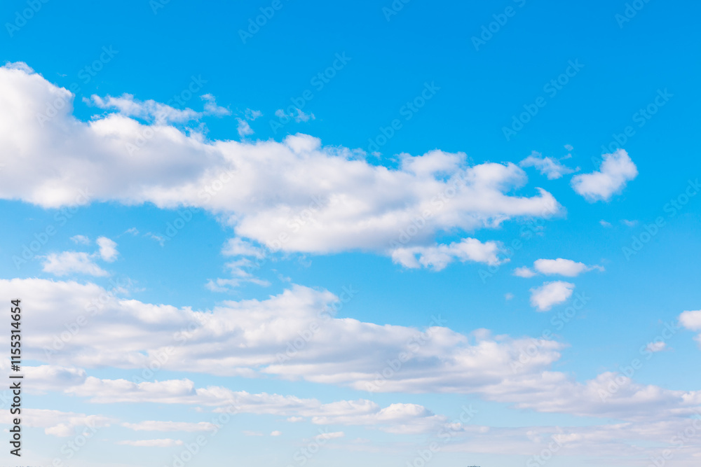 Bright blue sky featuring soft white clouds, evoking a sense of tranquility and openness. Bright heaven in the summer