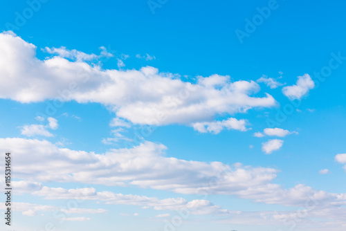 Obraz na płótnie Bright blue sky featuring soft white clouds, evoking a sense of tranquility and openness. Bright heaven in the summer w salonie