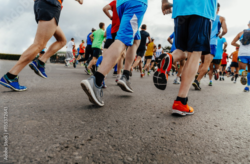 three runners behind large group people running city marathon photo