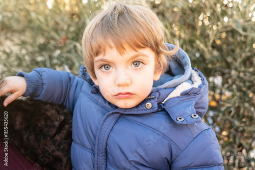 Little blue eyed caucasian boy looking at camera photo