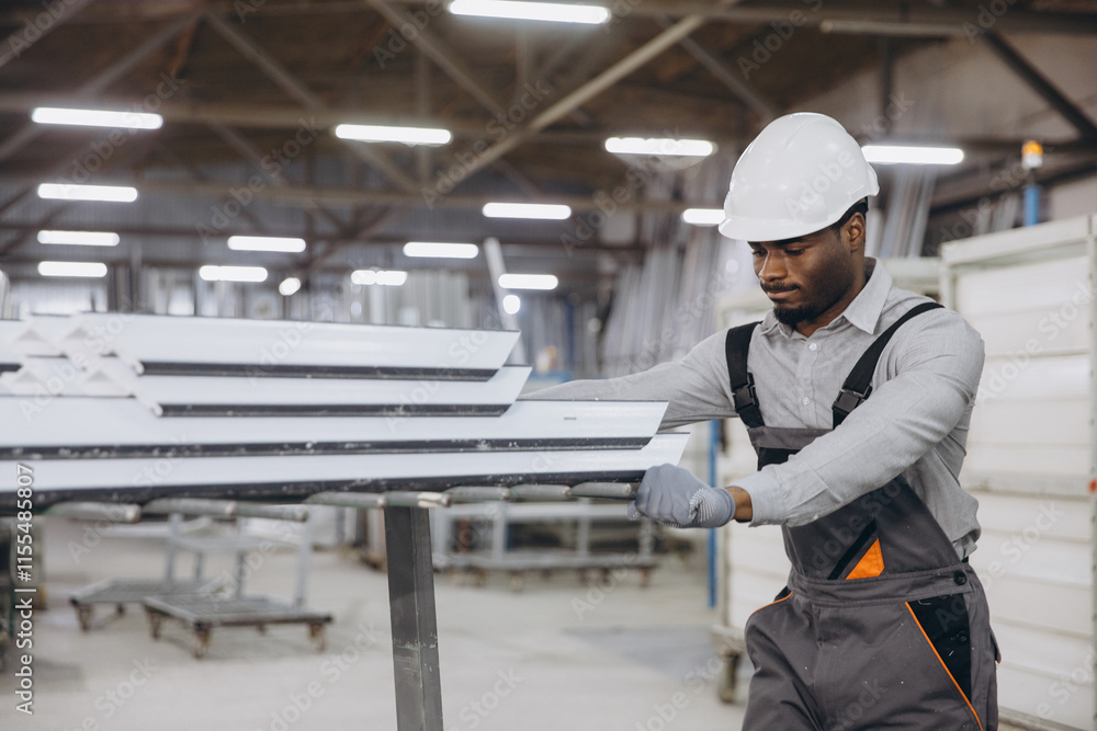 Factory worker moving aluminum window profiles Factory worker moving aluminum window profiles