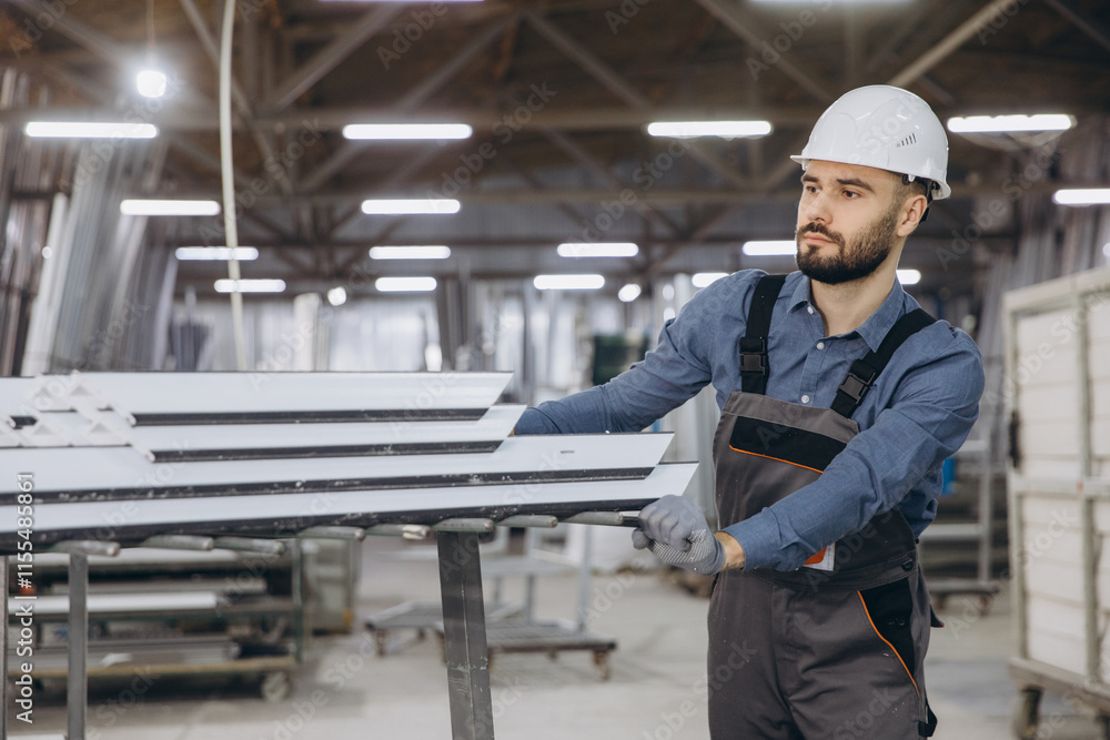 Factory worker moving aluminum window profiles in warehouse Factory worker moving aluminum window profiles in warehouse