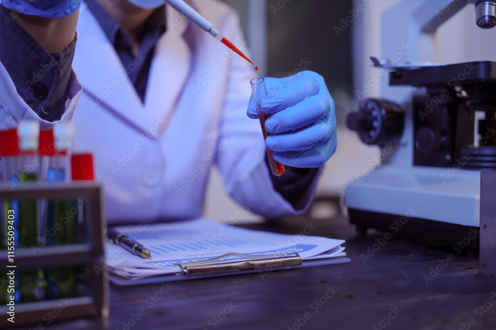 Fototapeta premium Close-up of a male scientist analyzing blood vessels in a modern laboratory. He is experimenting with chemicals in liquids, showing the scientific innovations in cutting-edge biomedical research