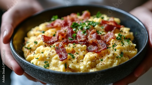 Delicious breakfast platter featuring scrambled eggs, bacon, toast, and green...