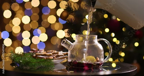 aromatic winter tea from currant berries, lemon and next to it gingerbread cookies for Christmas on a dark background
