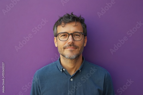 Man stands confidently against vibrant pink wall in urban setting during dayl...