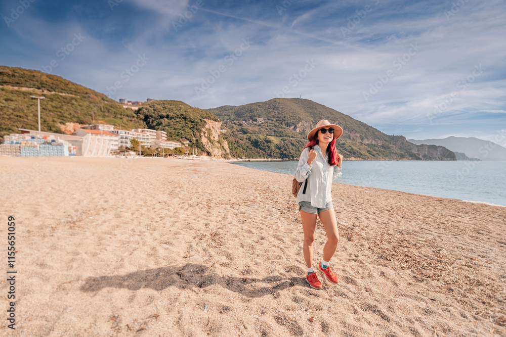 Tourist walking on the beach of Jaz, Montenegro, enjoying summer vacation Tourist walking on the beach of Jaz, Montenegro, enjoying summer vacation