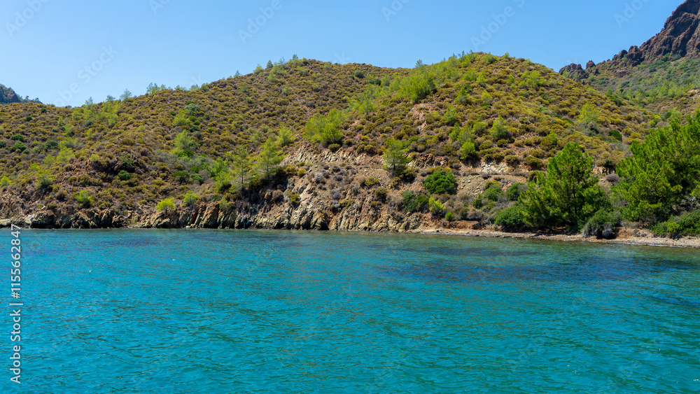 Fototapeta premium Aquarium bay in Aegean Sea with blue, turquoise and green water. Turkish islands, Boat trips along Aegean islands in Turkey to swim or snorkel