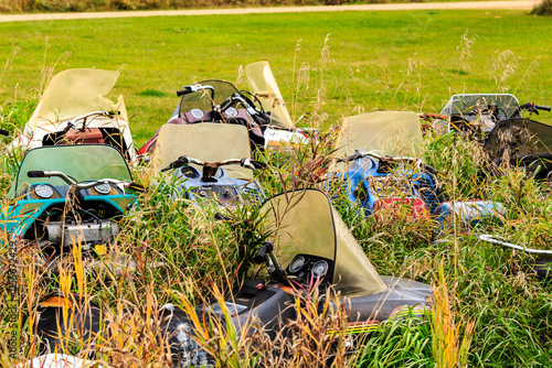 Fotografi A bunch of old snowmobiles are sitting in a field