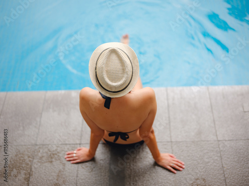 Photography Young asian woman relaxing by pool at Kuala Lumpur hotel with view of surrounding skyscrapers, enjoying leisure time in vibrant urban setting
