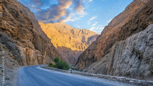 Scenic Mountain Road Through Gorge at Sunset with Majestic Peaks and Dramatic Sky Ideal for Travel and Adventure Themes photo