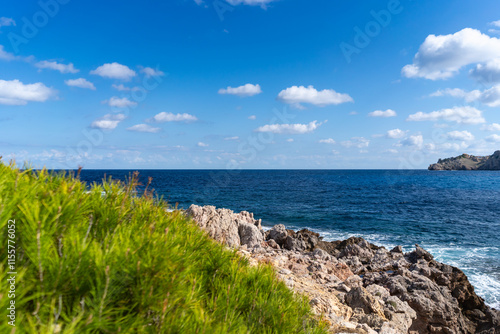 Cala Agulla, Mallorca, Spain, October 27, 2021 - Rocky Mediterranean coastline with native plants and deep blue sea waters.