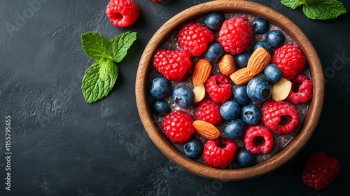 Bright and fresh berry bowl with almonds and mint on a dark surface