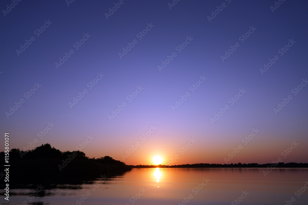 Fototapeta premium Couchers de soleil à Guma lagoon dans le delta de l'Okavango au Botswana