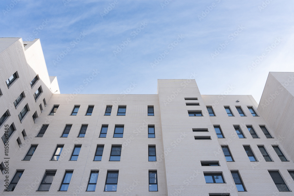 low-angle view of modern apartment building against a clear blue sky low-angle view of modern apartment building against a clear blue sky