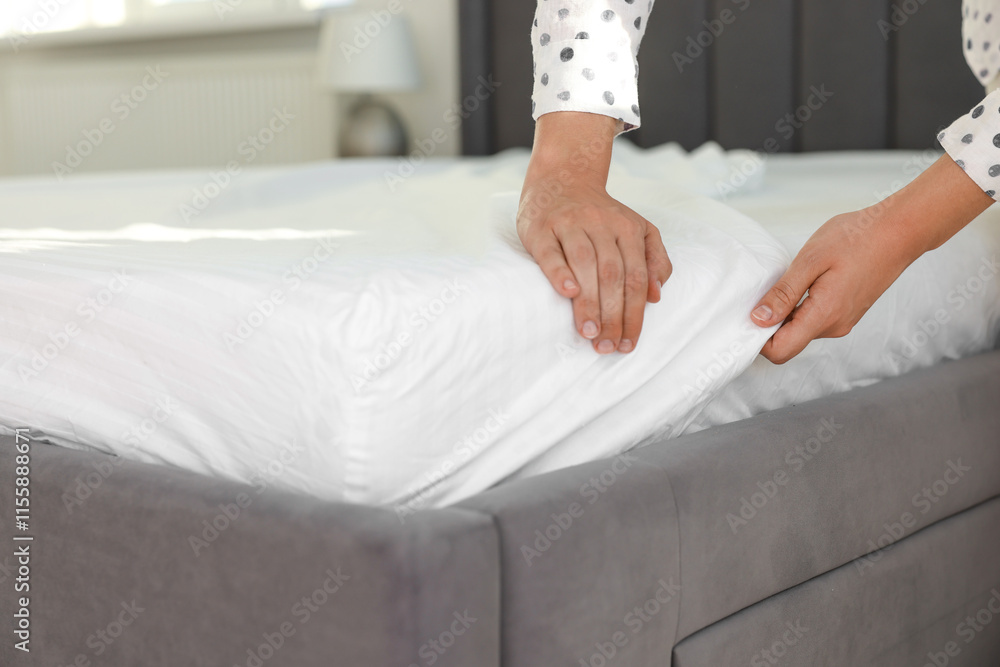 Woman changing clean bed linens at home, closeup Woman changing clean bed linens at home, closeup