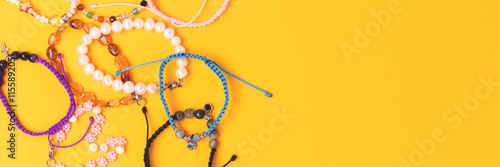 Banner with handmade bracelets made of beads and cords on a yellow background.
