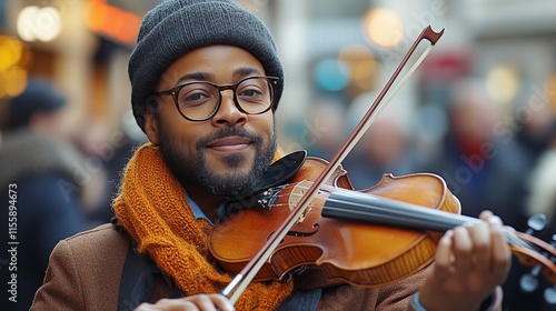 Musician playing violin in busy city street during winter while smiling at pa...