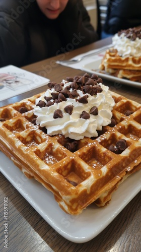 Delicious waffles topped with whipped cream and chocolate chips at a cozy bre...