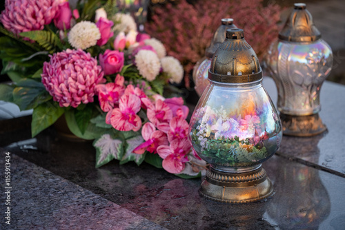 The grave is decorated with candles and beautiful purple peonies. photo