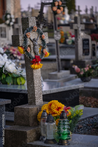 A cross on a grave decorated with a floral wreath. photo